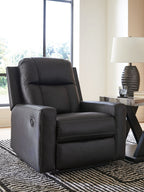 Dark charcoal zero-wall recliner with padded headrest, thick seat, and oval arm detail