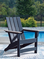 Adirondack chair on patio with dark navy slatted back and beige armrests