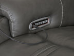 Dark gray reclining seat side power control panel with cord and button slot