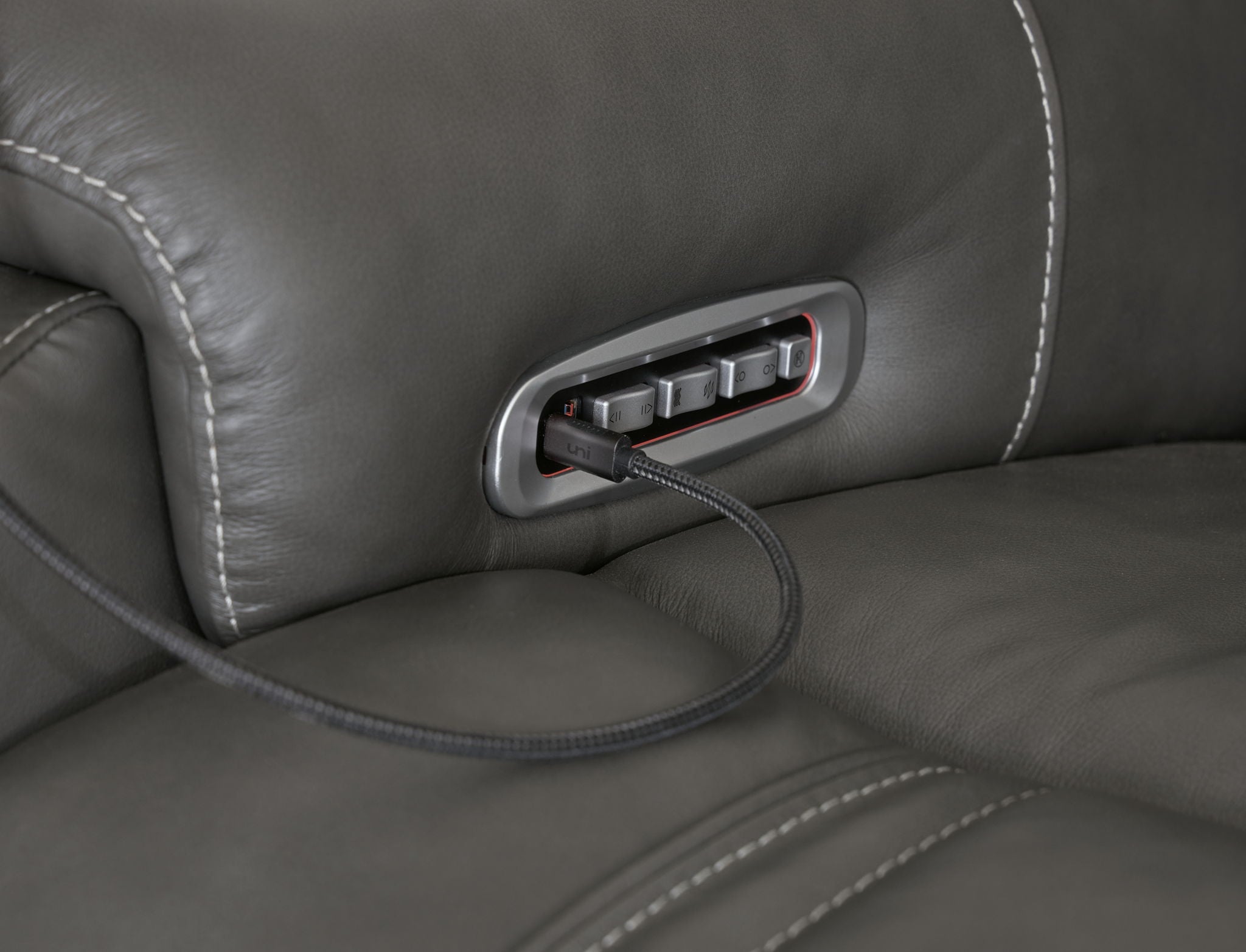 Dark gray reclining seat side power control panel with cord and button slot