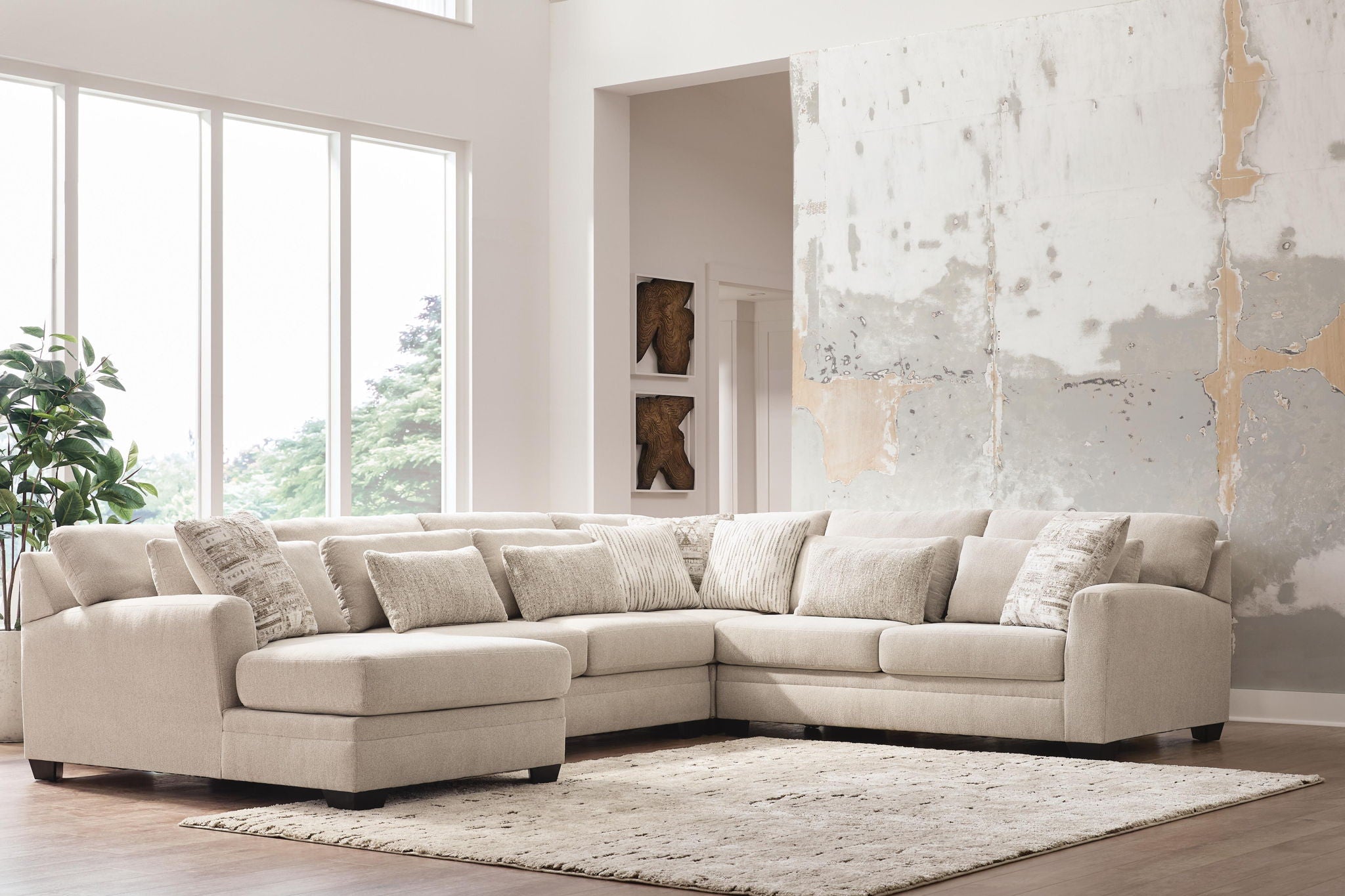 Light beige sectional sofa with chaise and mix of solid and patterned throw pillows