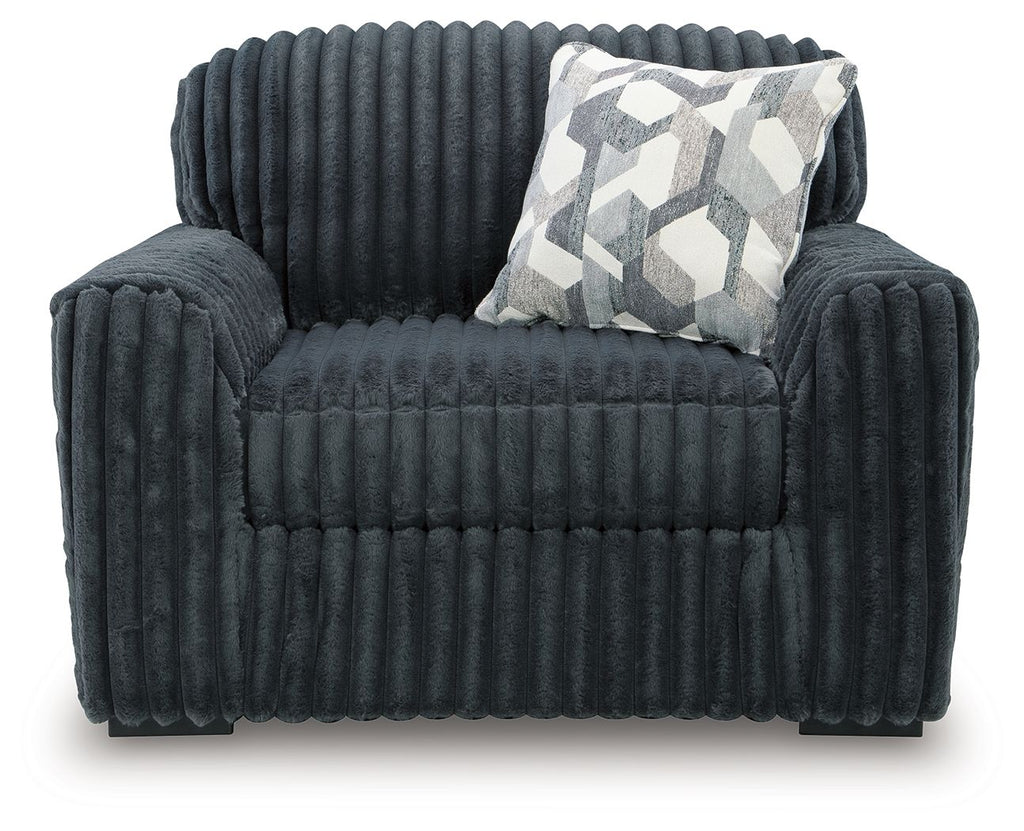 Dark gray chair and a half with quilted seat and geometric throw pillow