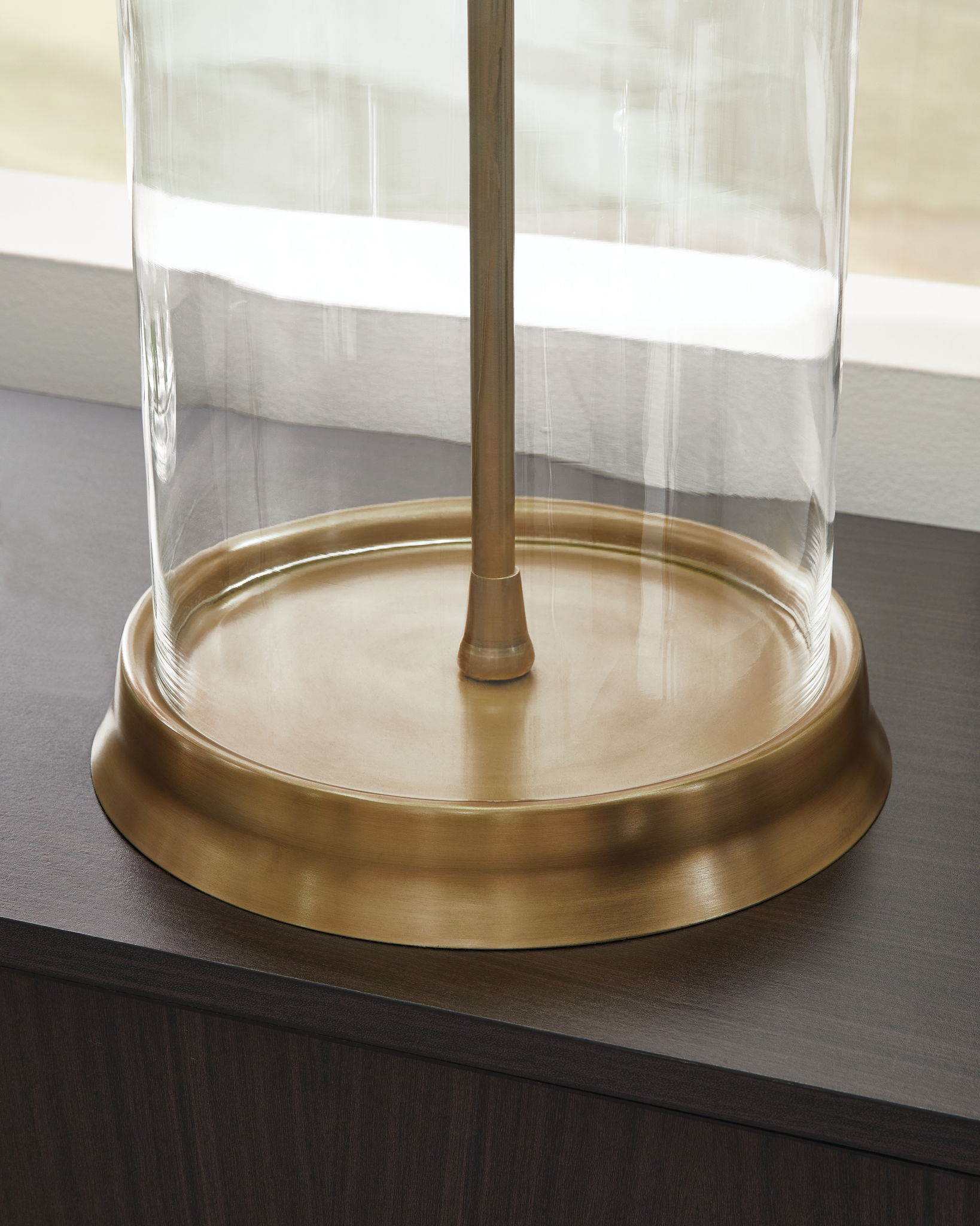 Clear glass table lamp with gold round base and vertical stem