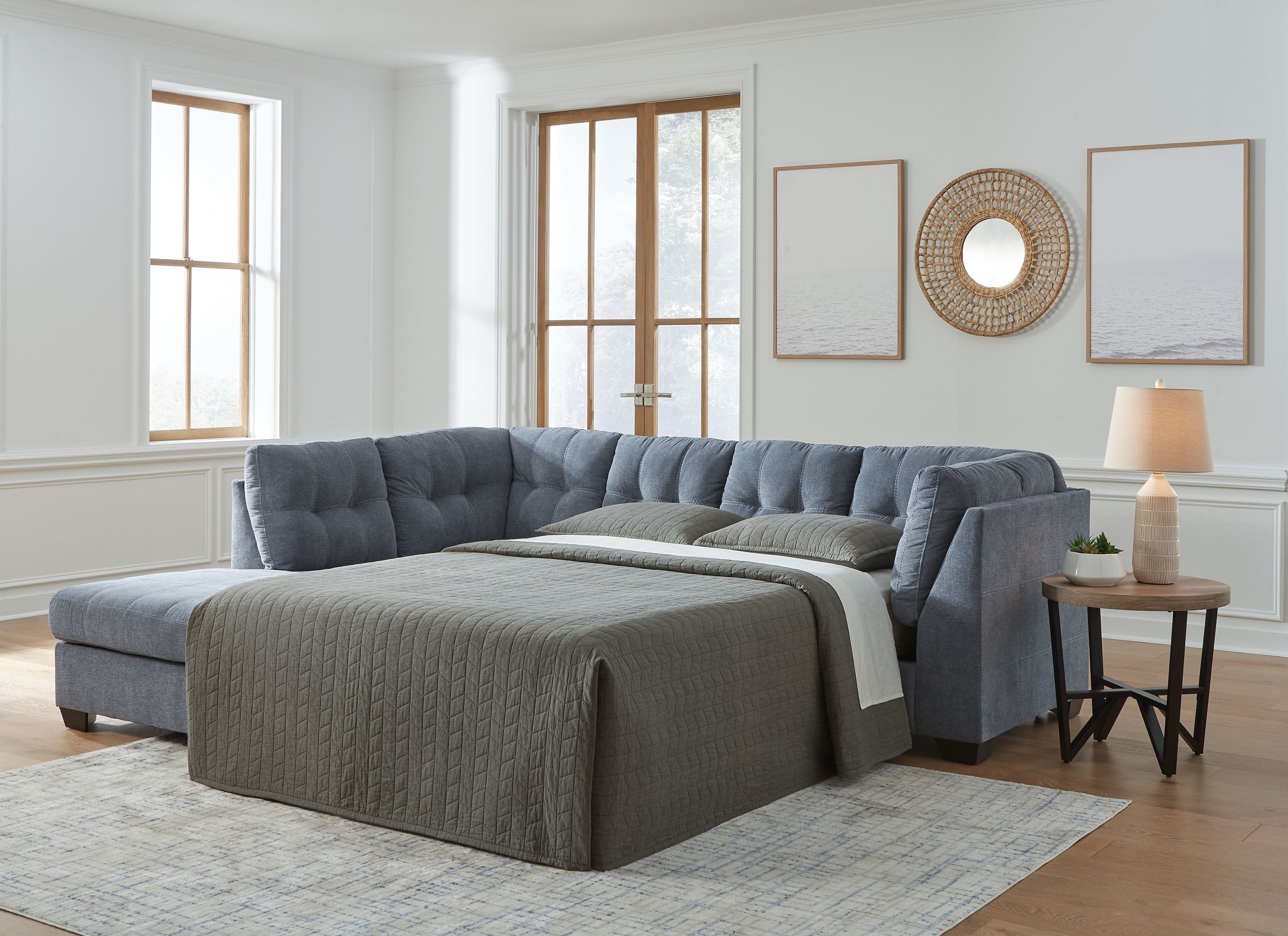Blue denim full sofa sleeper with pull-out bed, tufted back and arm cushions.