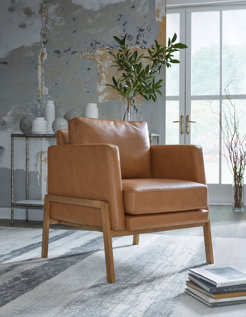 Caramel accent chair with leather-look upholstery, padded arms, and front panel detail