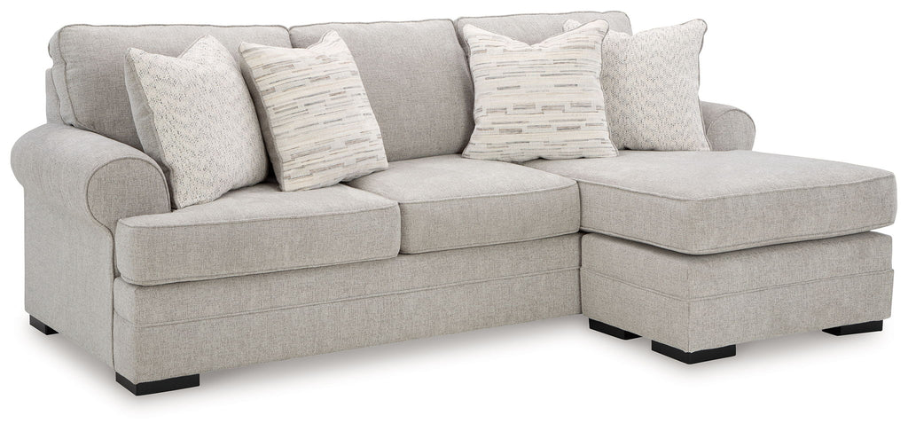 Gray upholstered sectional sofa with chaise and multiple throw pillows