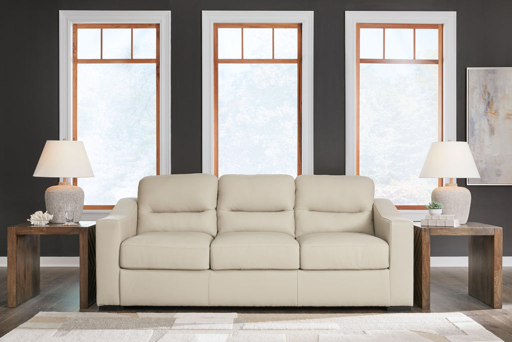 Almond upholstered sofa with three seat cushions and matching throw pillows
