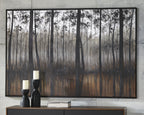 Framed forest wall art with vertical black tree silhouettes over gray and dark brown.