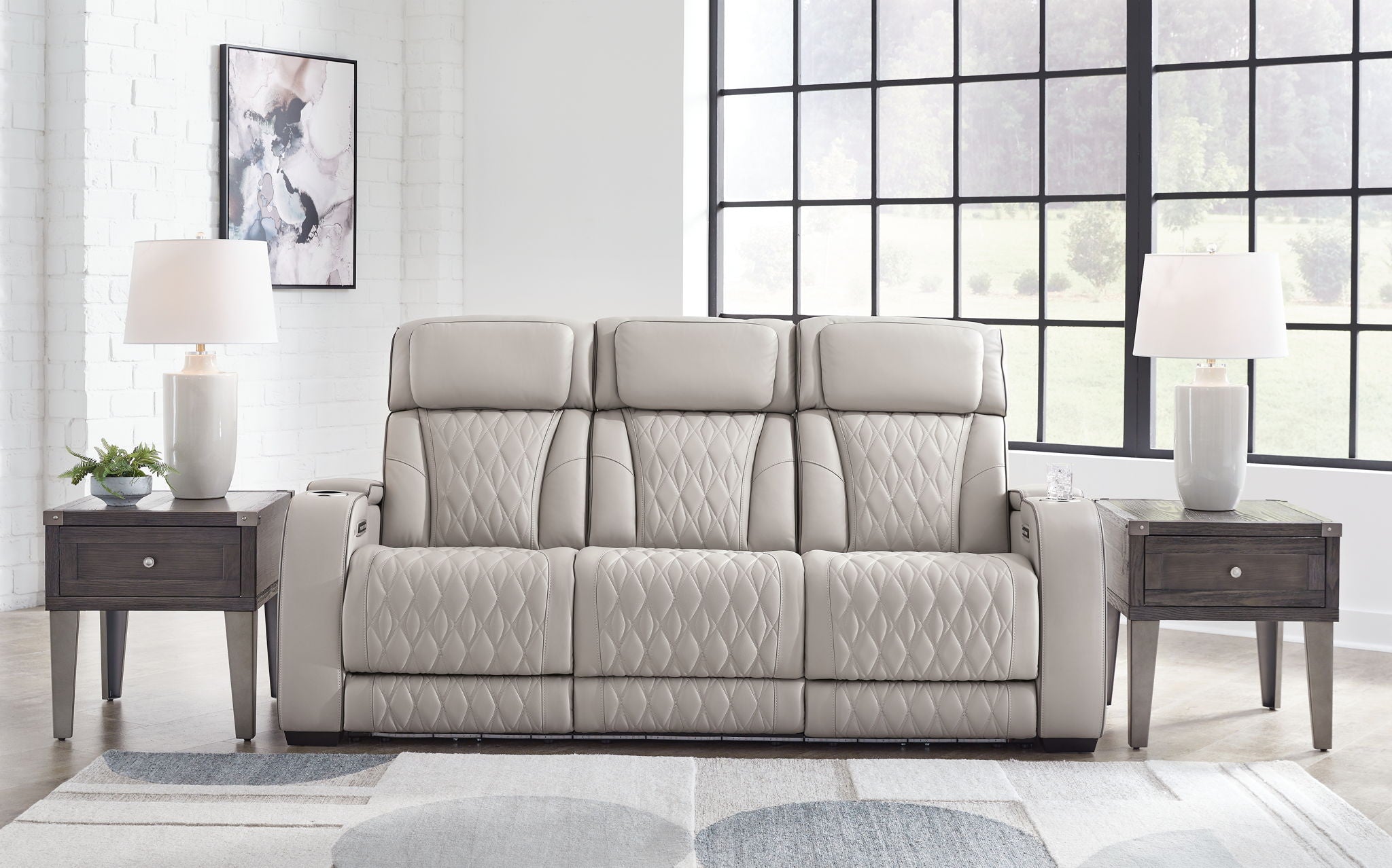 Gray 3-seat reclining sofa with quilted upholstery and three padded headrests