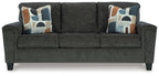 Black upholstered sofa with three seat cushions and four patterned throw pillows