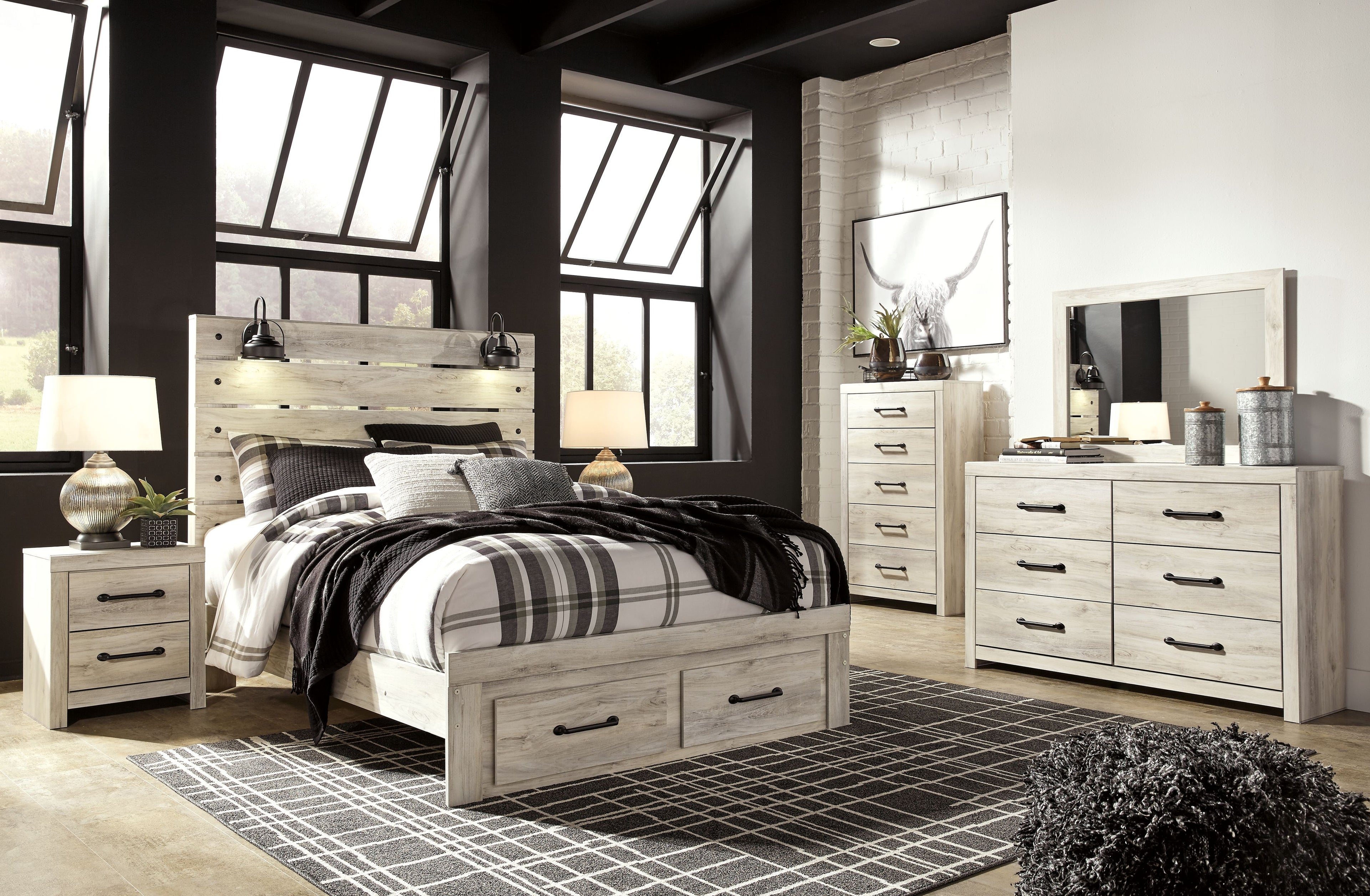 Bedroom set with light wood bed and striped plaid bedding, plus dresser mirror and nightstand lamps