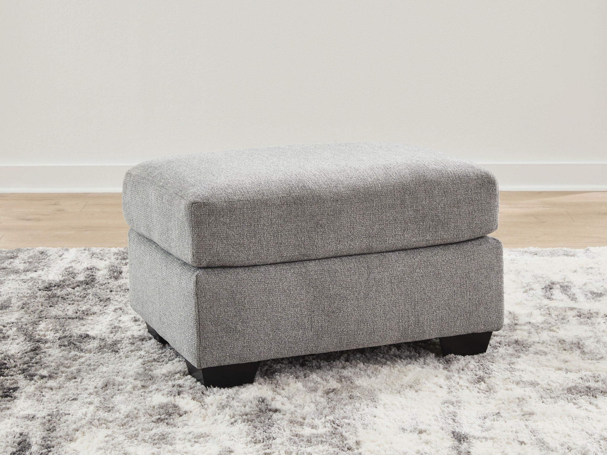 Gray fabric ottoman with rectangular top and dark block legs