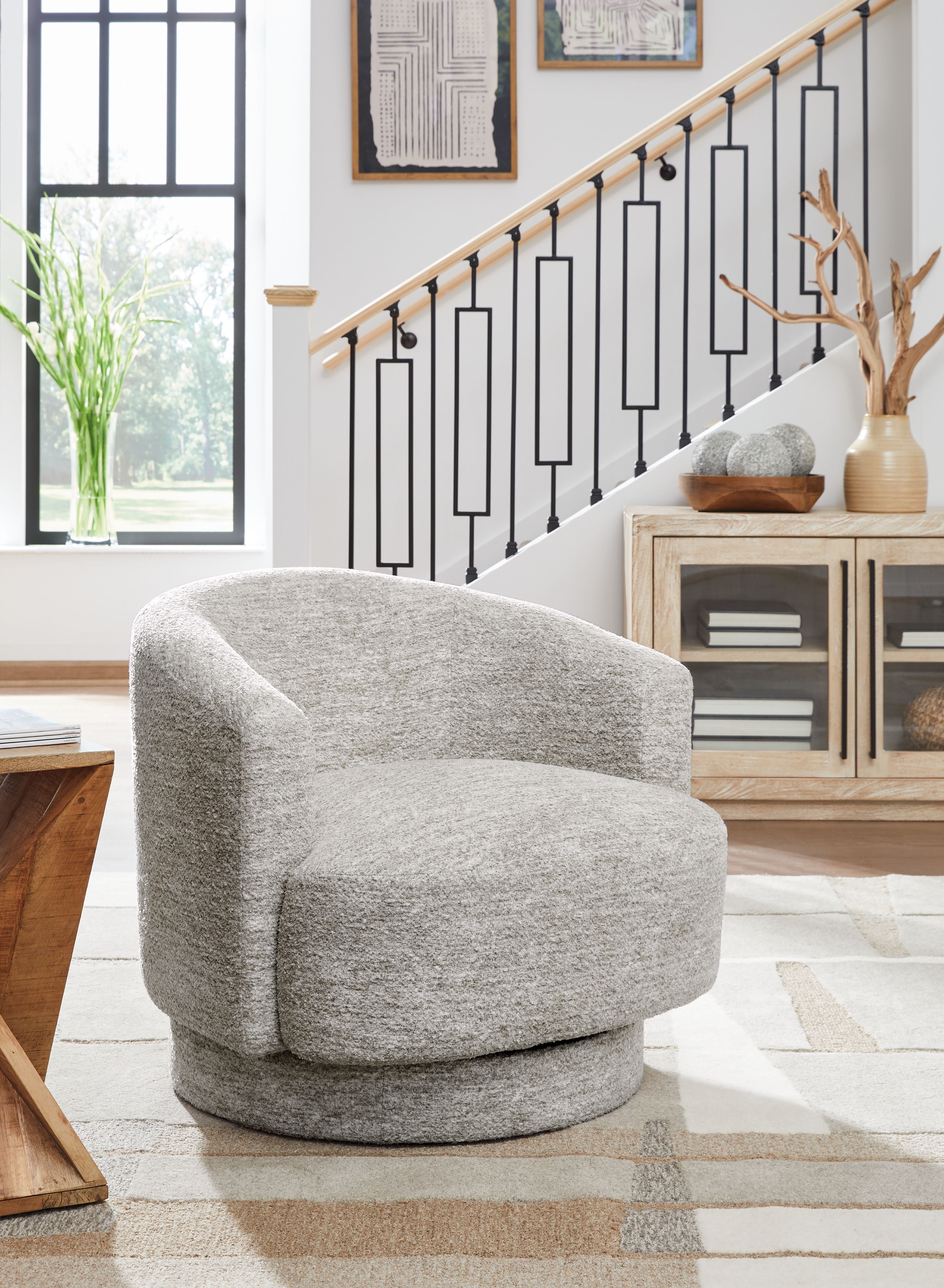 Wardsor swivel chair in stone fabric, rounded arms and circular swivel base.