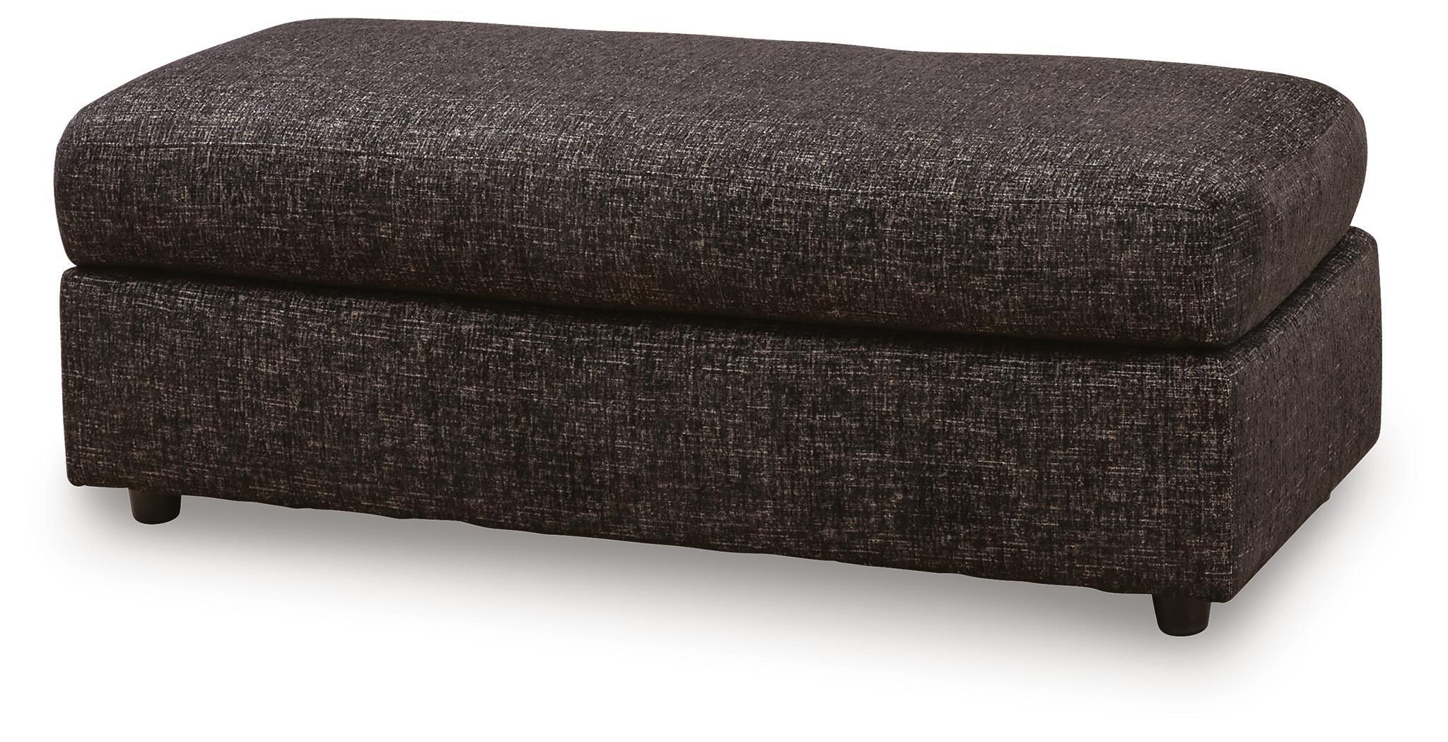 Oversized accent ottoman in dark woven fabric, cushioned seat, angled side view