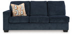 Ink blue fabric sofa front view with square arms, three seat cushions, and patterned throw pillow