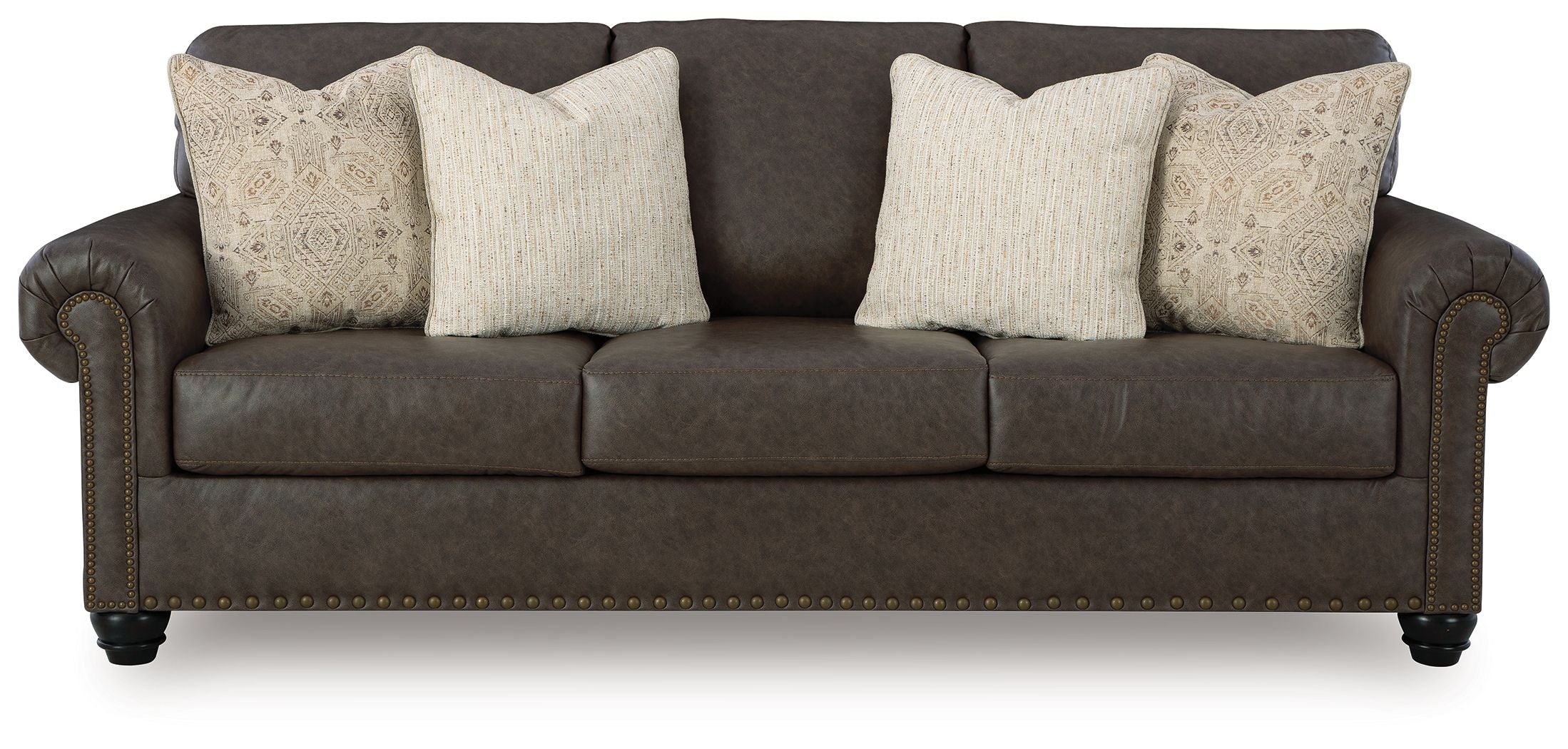 Dark brown sofa with four beige patterned pillows, rolled arms, and studded base