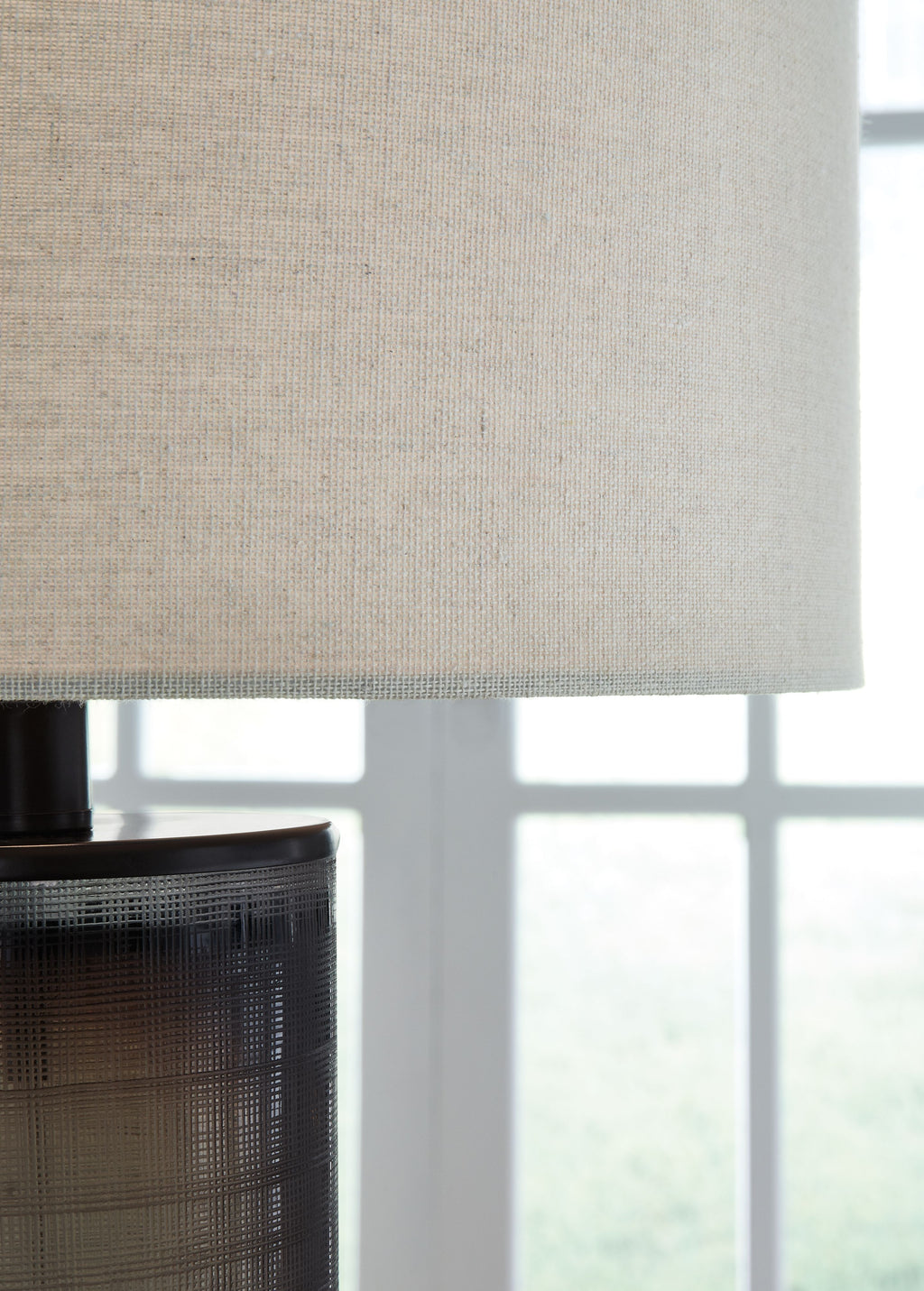 Beige fabric drum lampshade over dark brown ribbed glass base