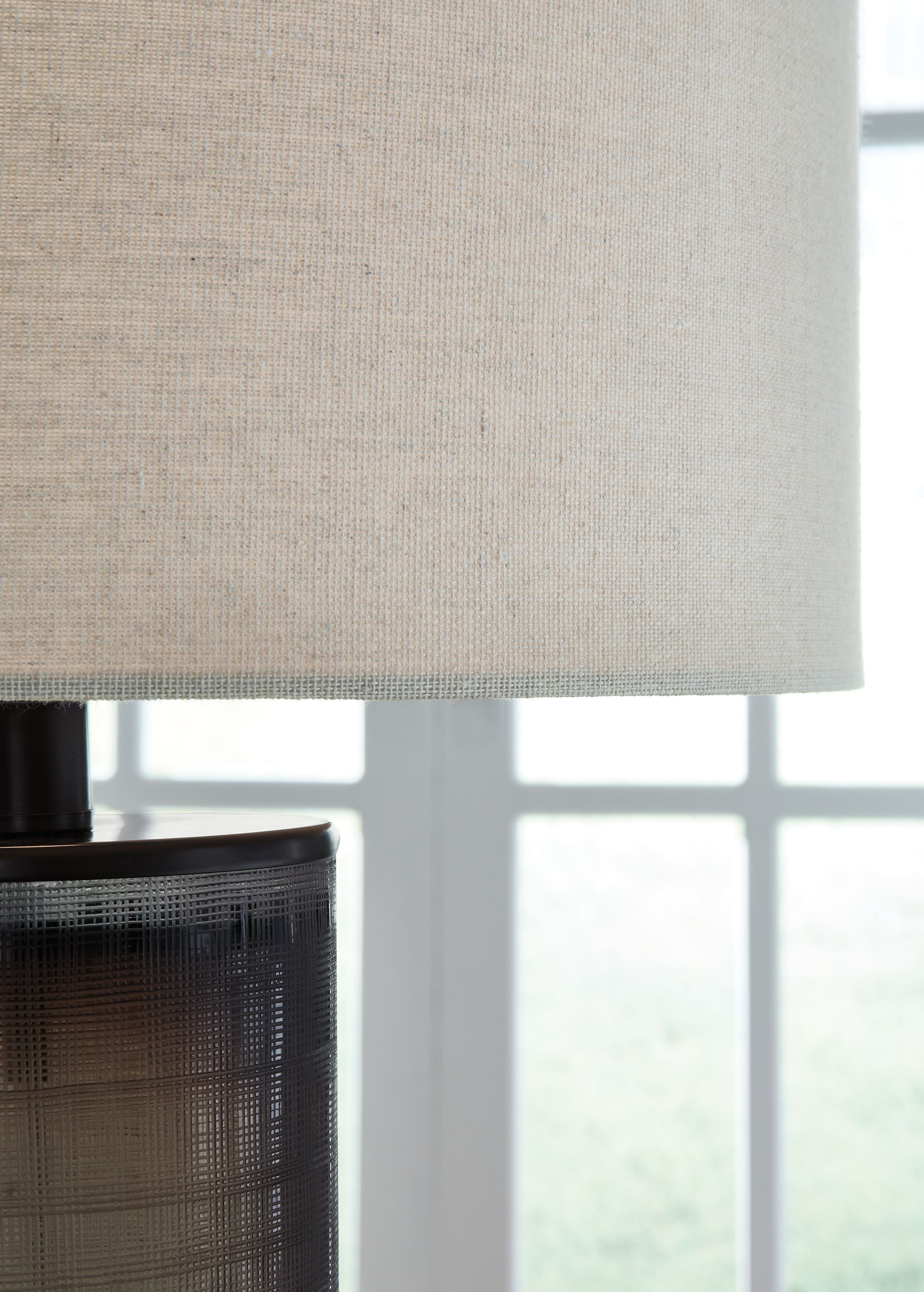 Beige fabric drum lampshade over dark brown ribbed glass base