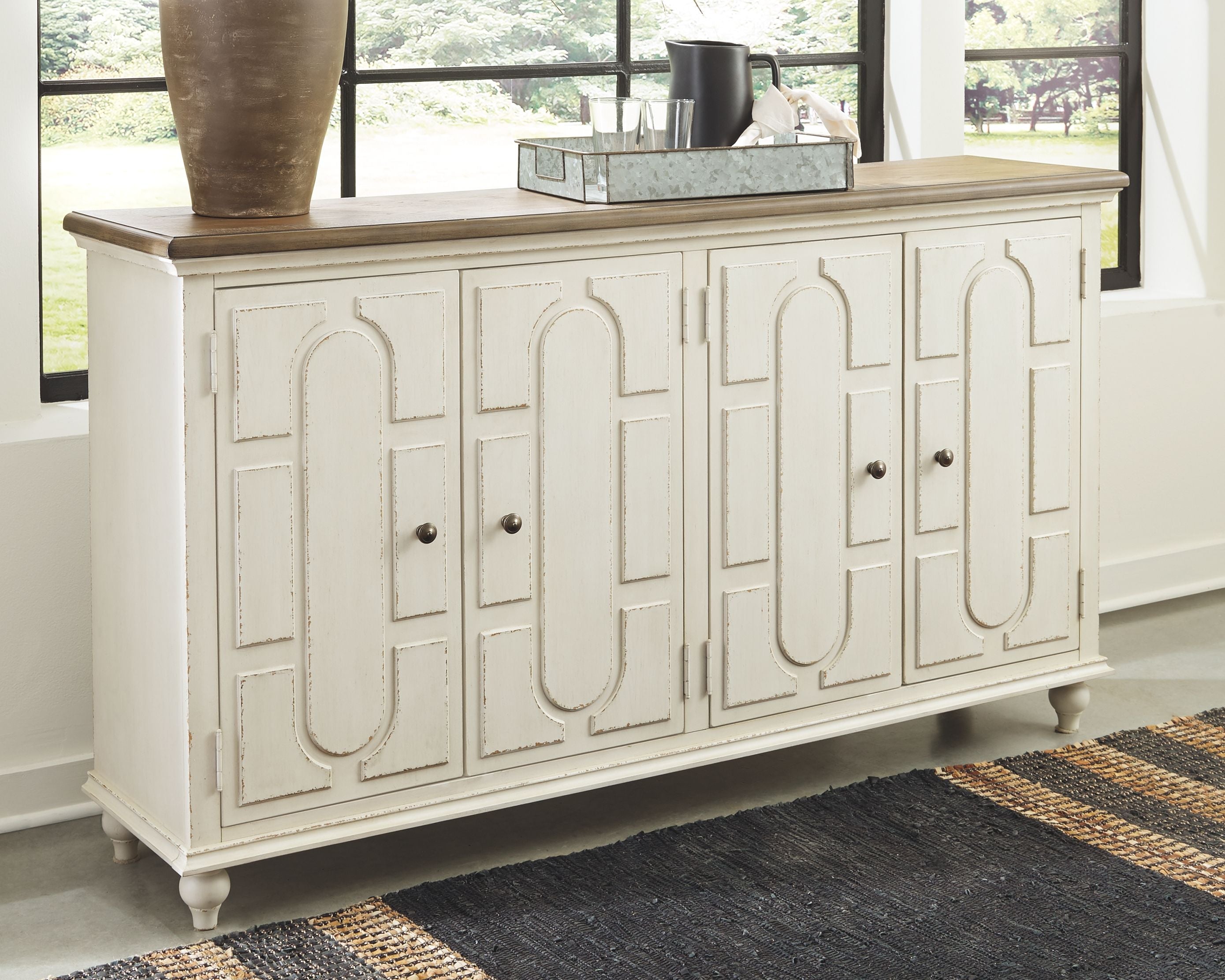 Antique white accent cabinet with carved doors, dark pulls, and wood top