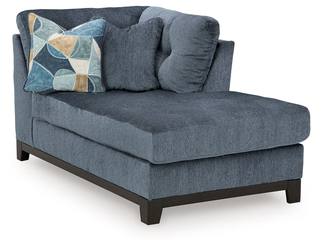 Navy corner chaise with tufted seat, rolled backrest, and geometric pillow