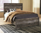 Gray wood panel bed with tall headboard and low footboard, with layered bedding