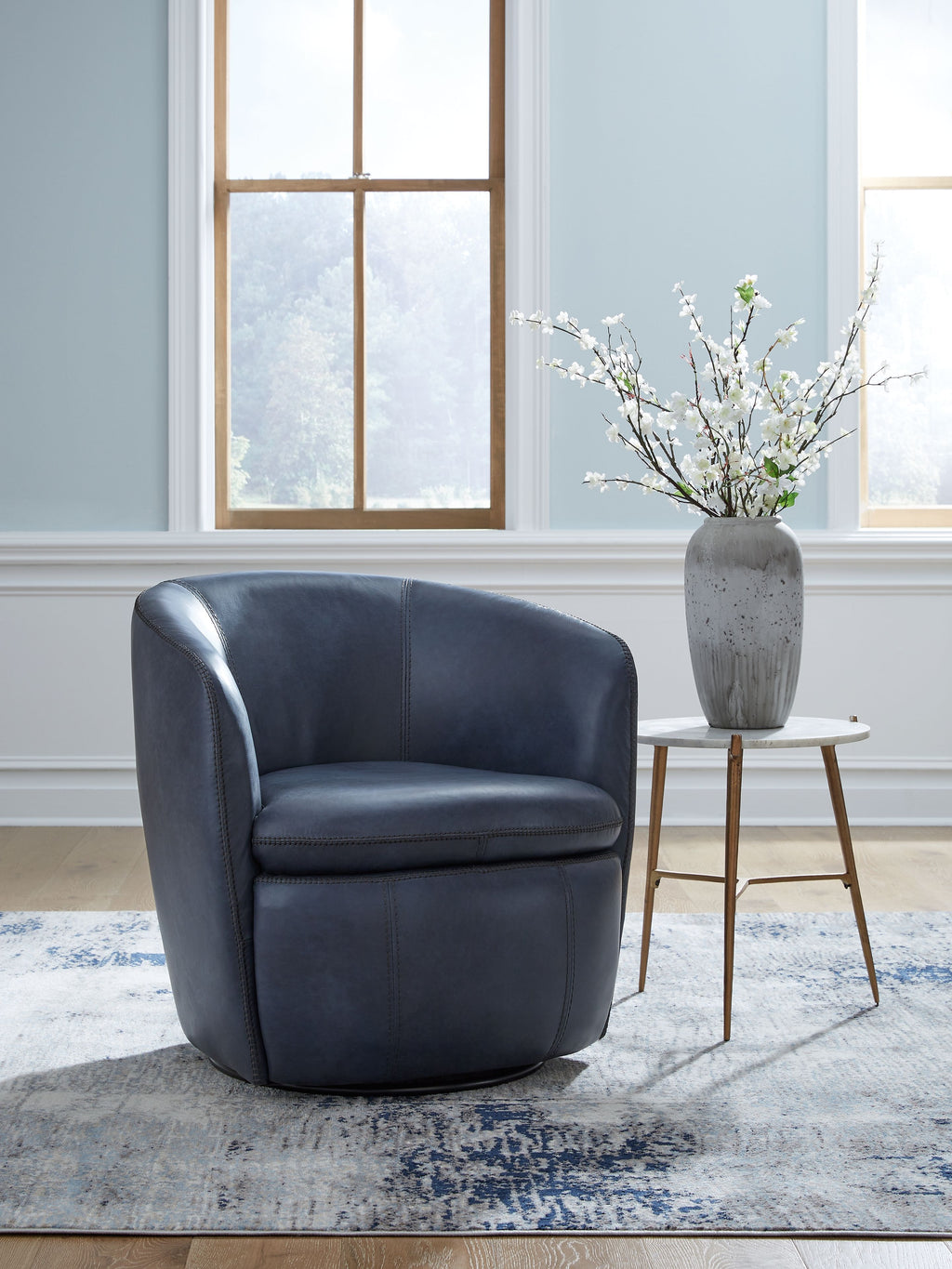 Blue upholstered swivel chair with rounded arms and low curved back