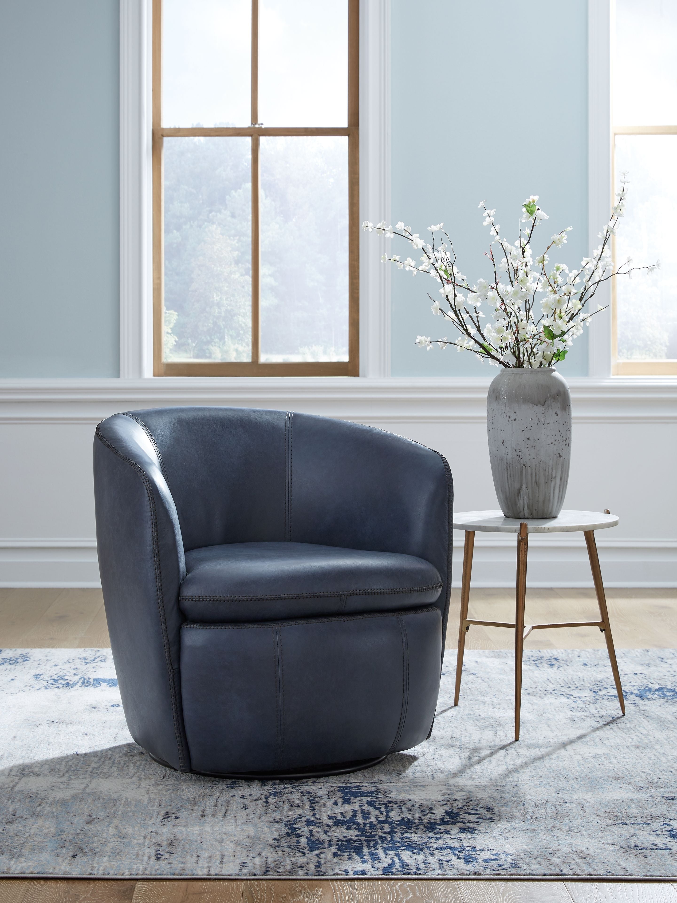 Blue upholstered swivel chair with rounded arms and low curved back