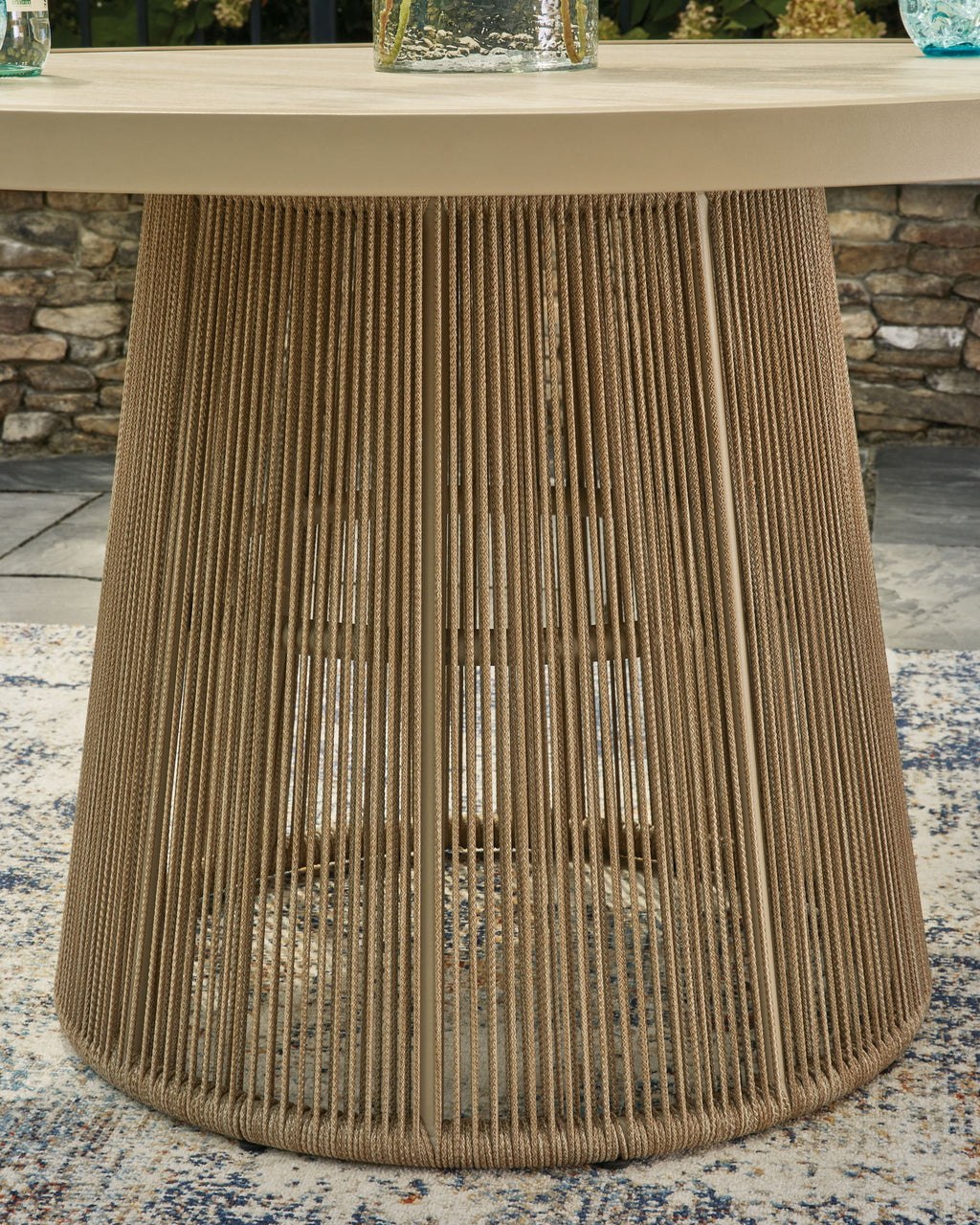 Beige outdoor dining table pedestal base with vertical woven cords