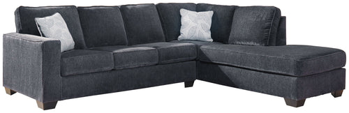 Dark gray sectional sleeper sofa with chaise, tufted back, and multiple throw pillows