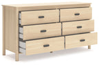 Light beige wood dresser with multiple drawers and black knobs, side view