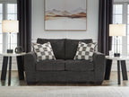 Dark gray loveseat with two plaid throw pillows