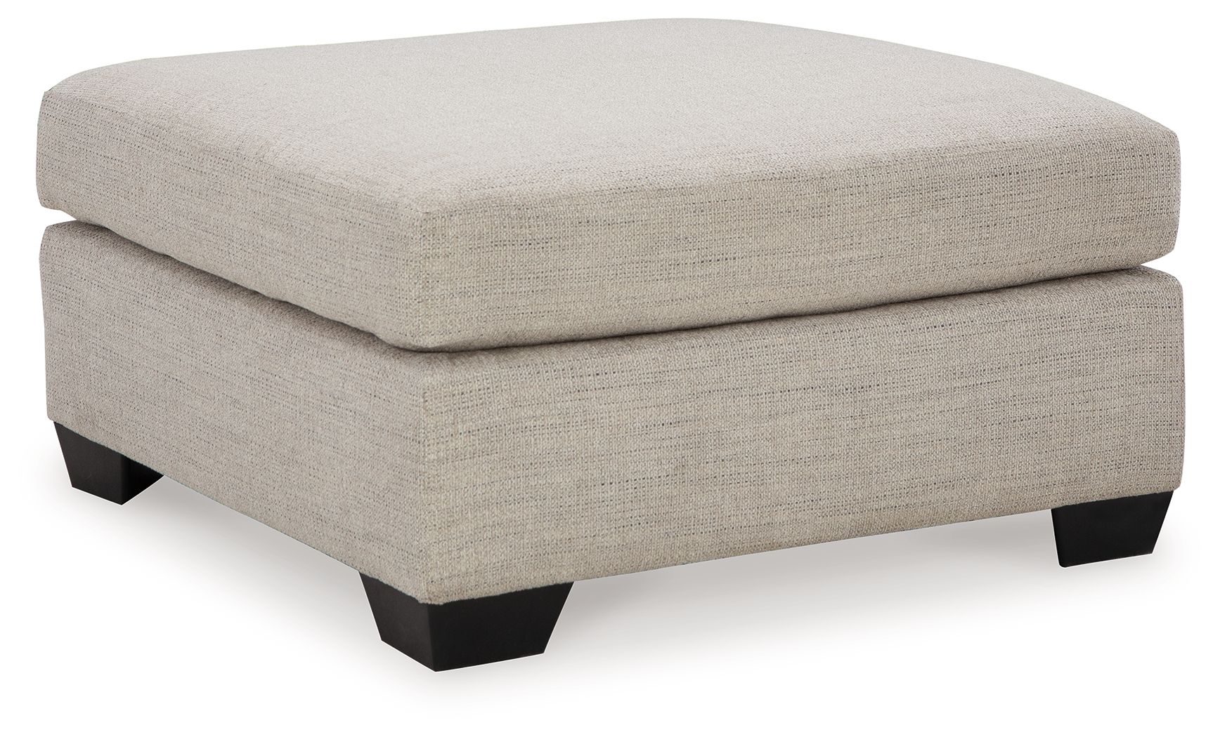 Oversized ottoman with light beige fabric, thick cushioned top and squared black legs.