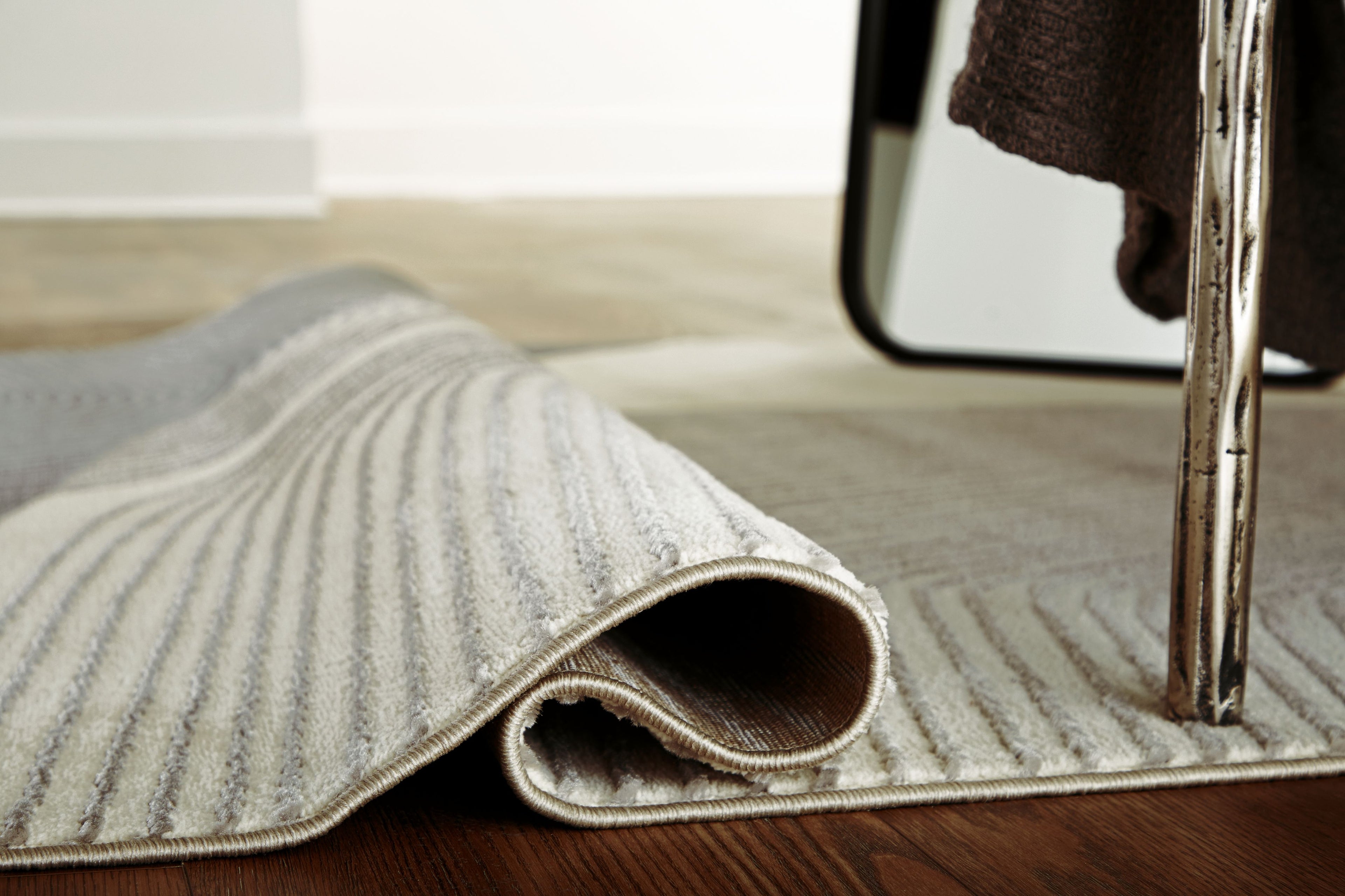 Winderburg rug edge rolled showing textured underside, wavy stripes