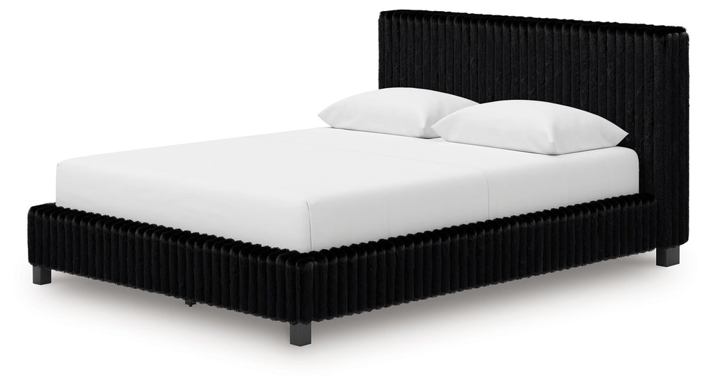 Black upholstered platform bed with tall headboard and two white pillows.