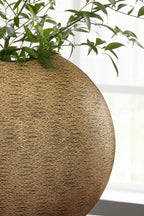 Gold textured vase close-up on curved side with dark rim opening