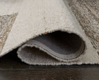 Barus rug with rolled edge showing gray backing and beige surface