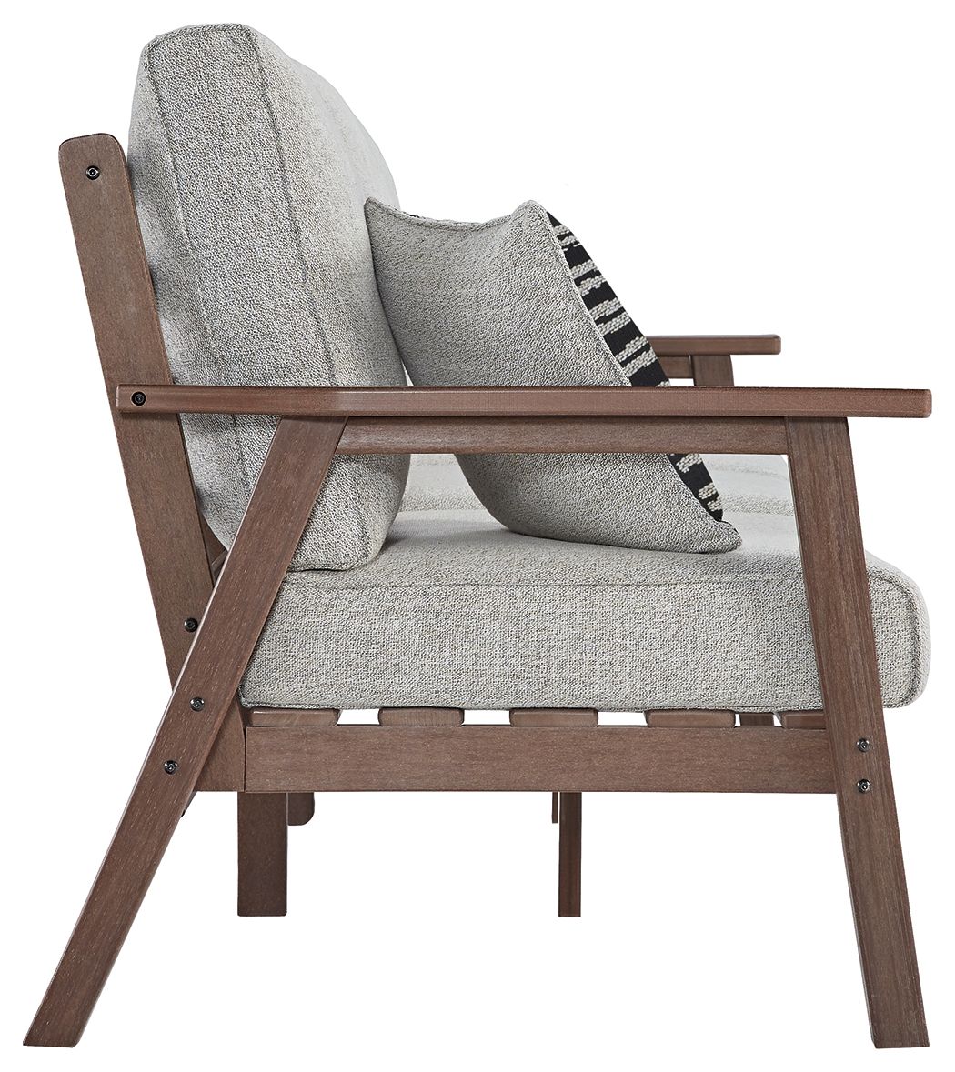 Grey upholstered sofa with brown wooden arms and black-and-white patterned pillow