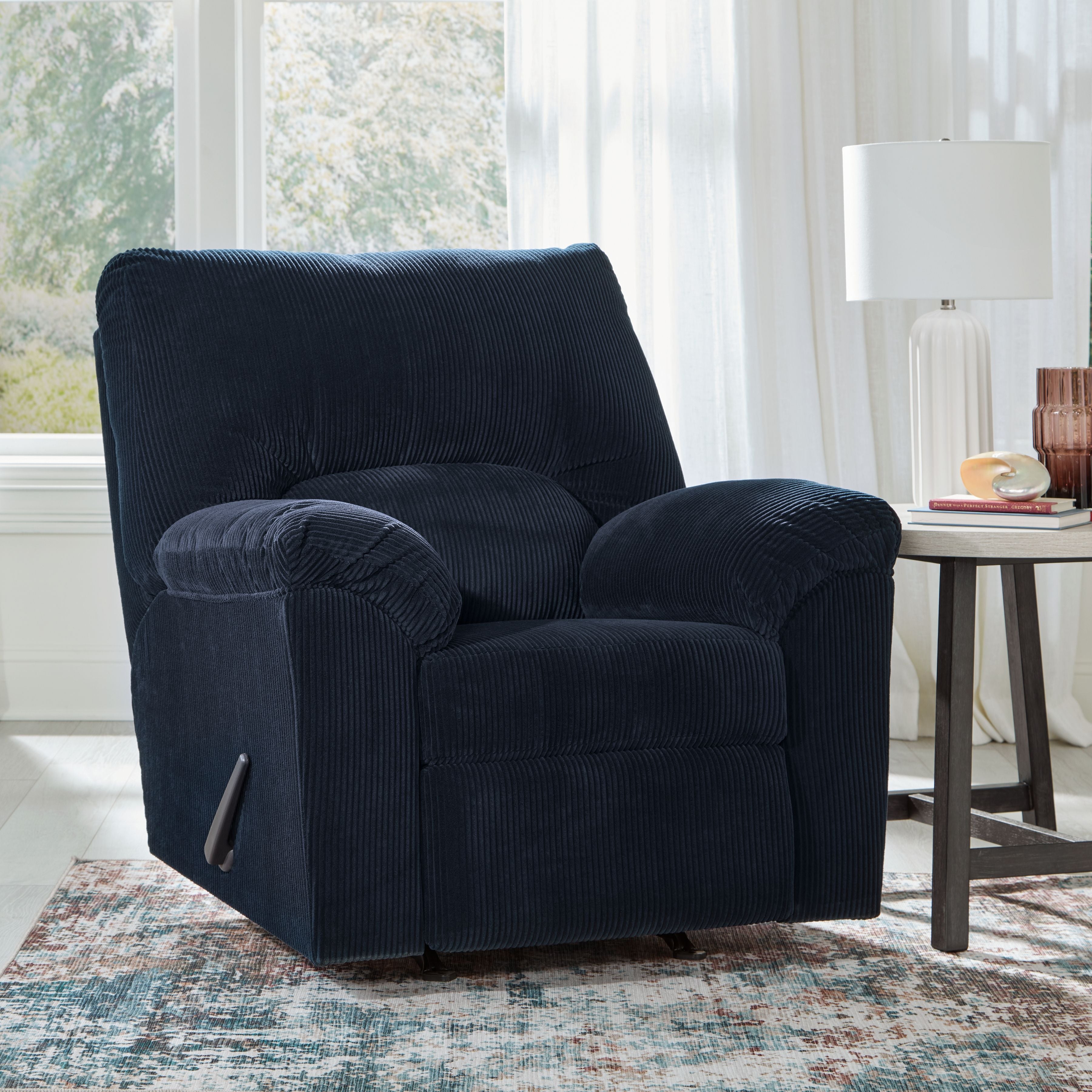 Rocker recliner chair in navy corduroy with tufted back, padded arms, footrest