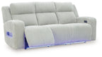 Power reclining sofa with adjustable headrests, light gray ribbed upholstery, reclined seat