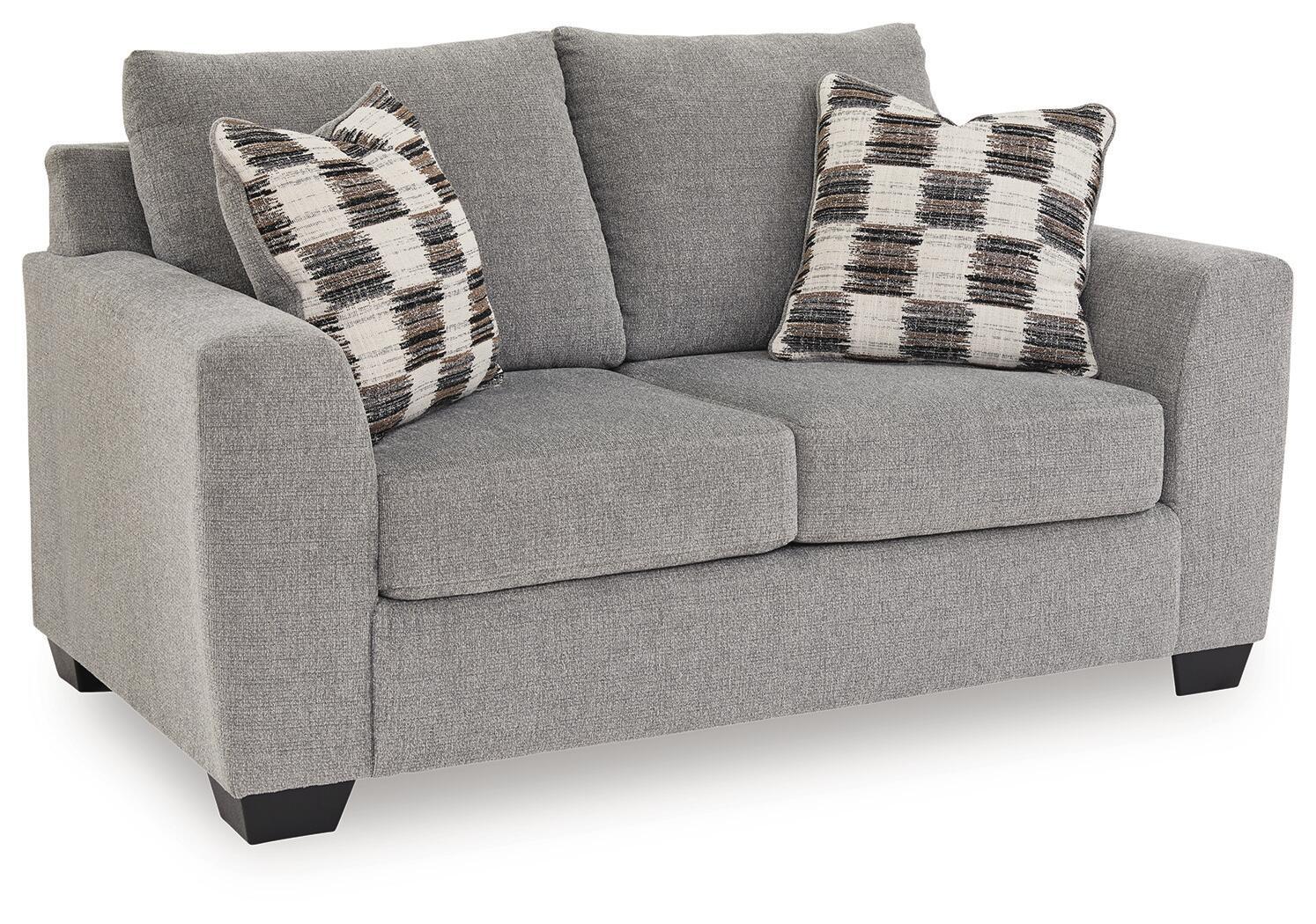 Medium gray loveseat with two plaid throw pillows and cushioned seat