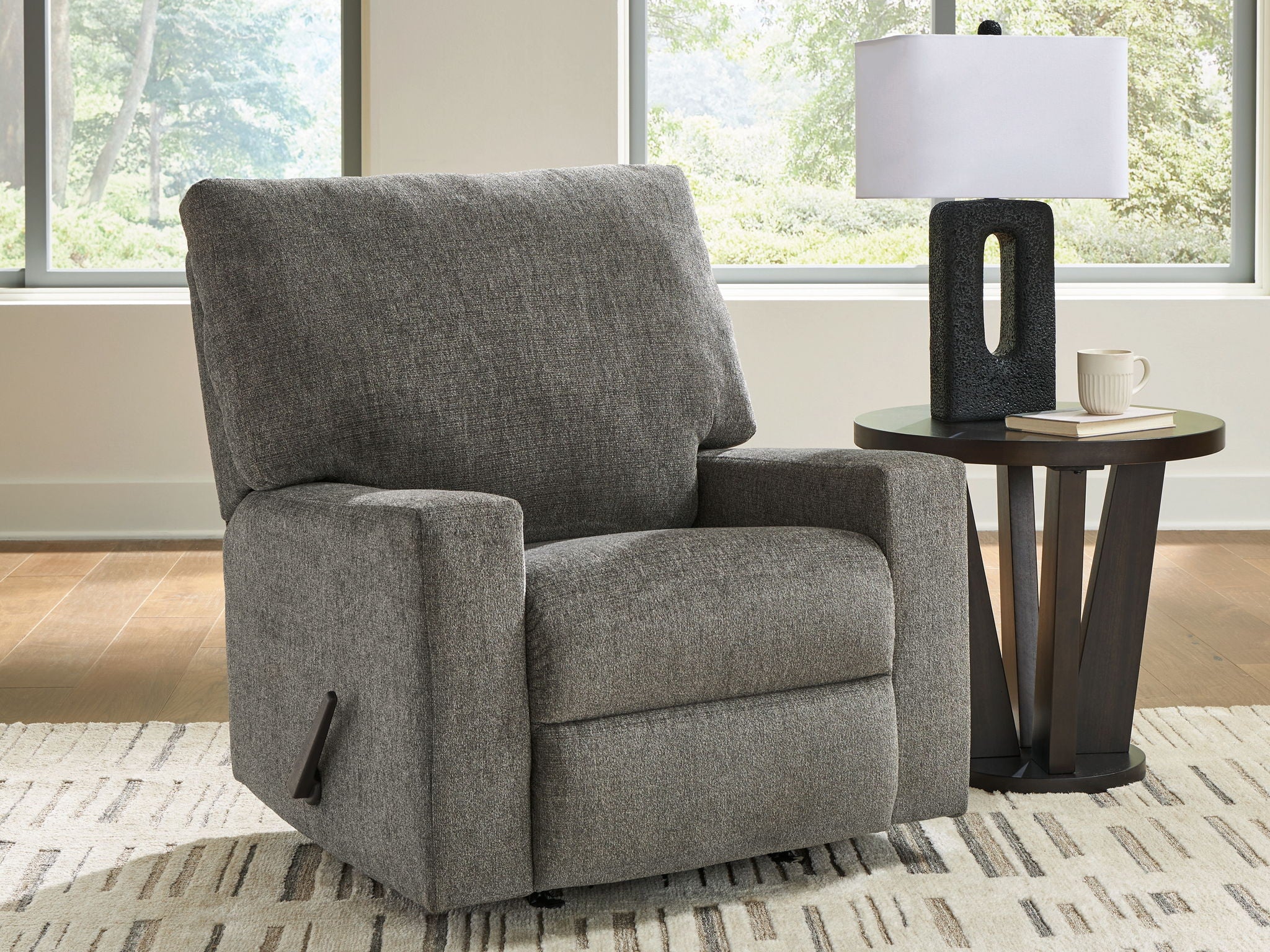 Gray upholstered recliner chair with padded arms and high backrest, black legs