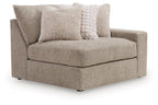 Gray corner chair with right-facing arm, one seat cushion, and two patterned throw pillows