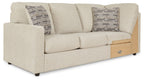 Pearl silver wedge sofa with three seat cushions, two patterned pillows, and wood side panel