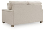 Light beige upholstered loveseat with rolled arms and three back cushions