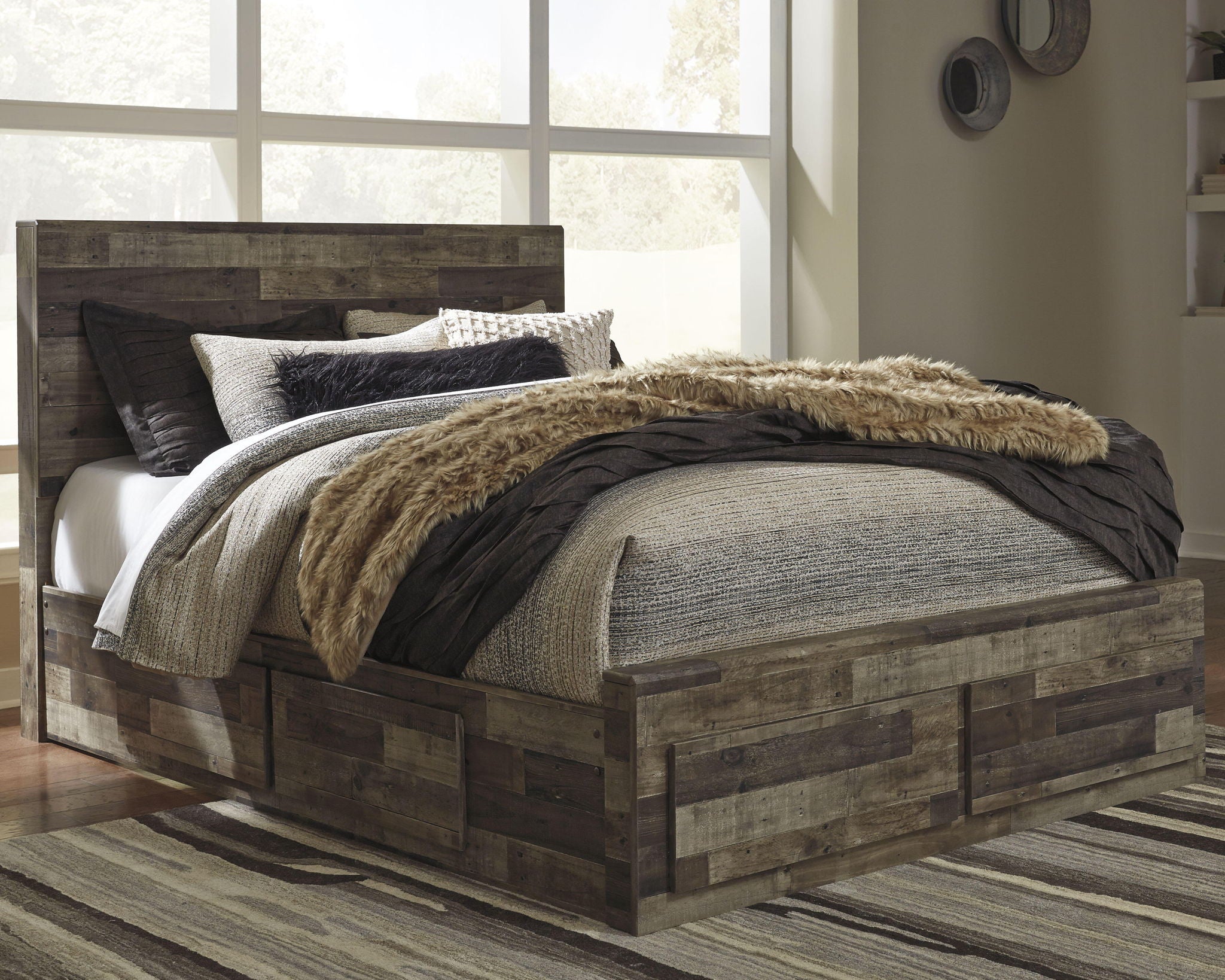 Dark wood panel bed with gray upholstered headboard, layered bedding, and faux-fur blanket