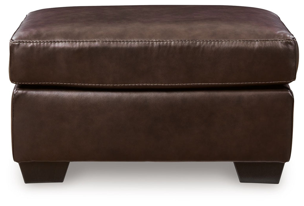 Dark brown upholstered ottoman with cushioned top, visible double-stitching, block legs