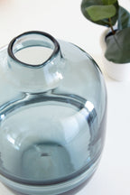Teal glass vase close-up from side, rounded shoulder and flared mouth.