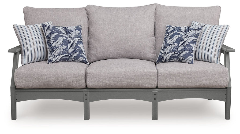 Gray outdoor sofa with three seat cushions and blue floral striped throw pillows