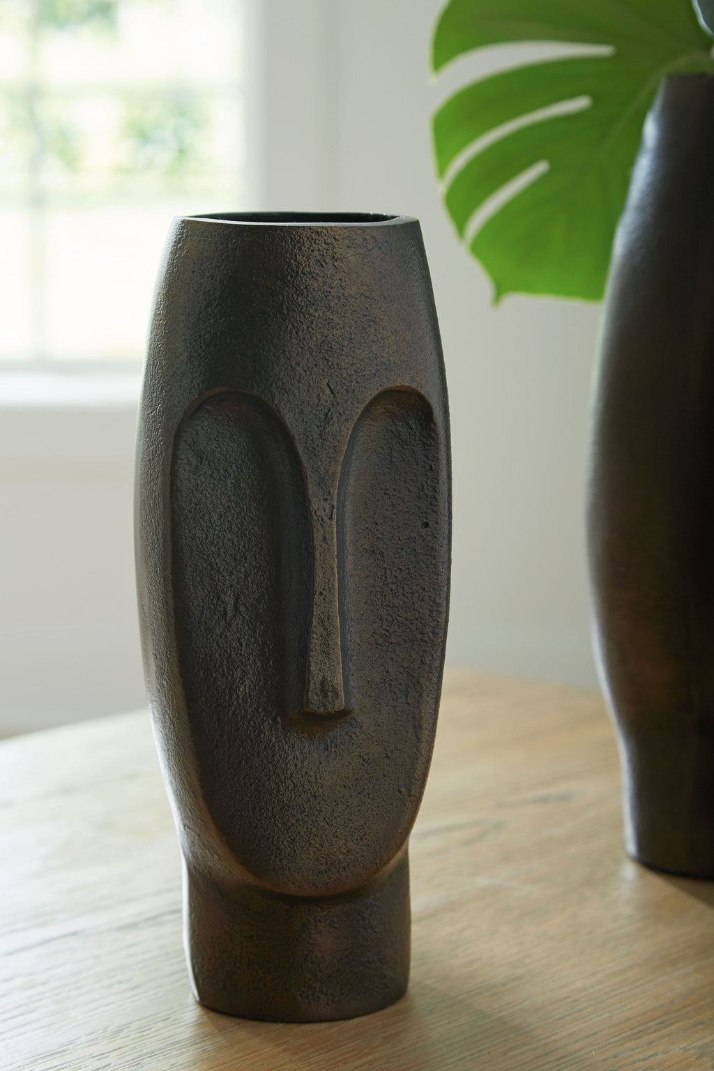 Bronze textured vase with arched cutout, standing on tabletop