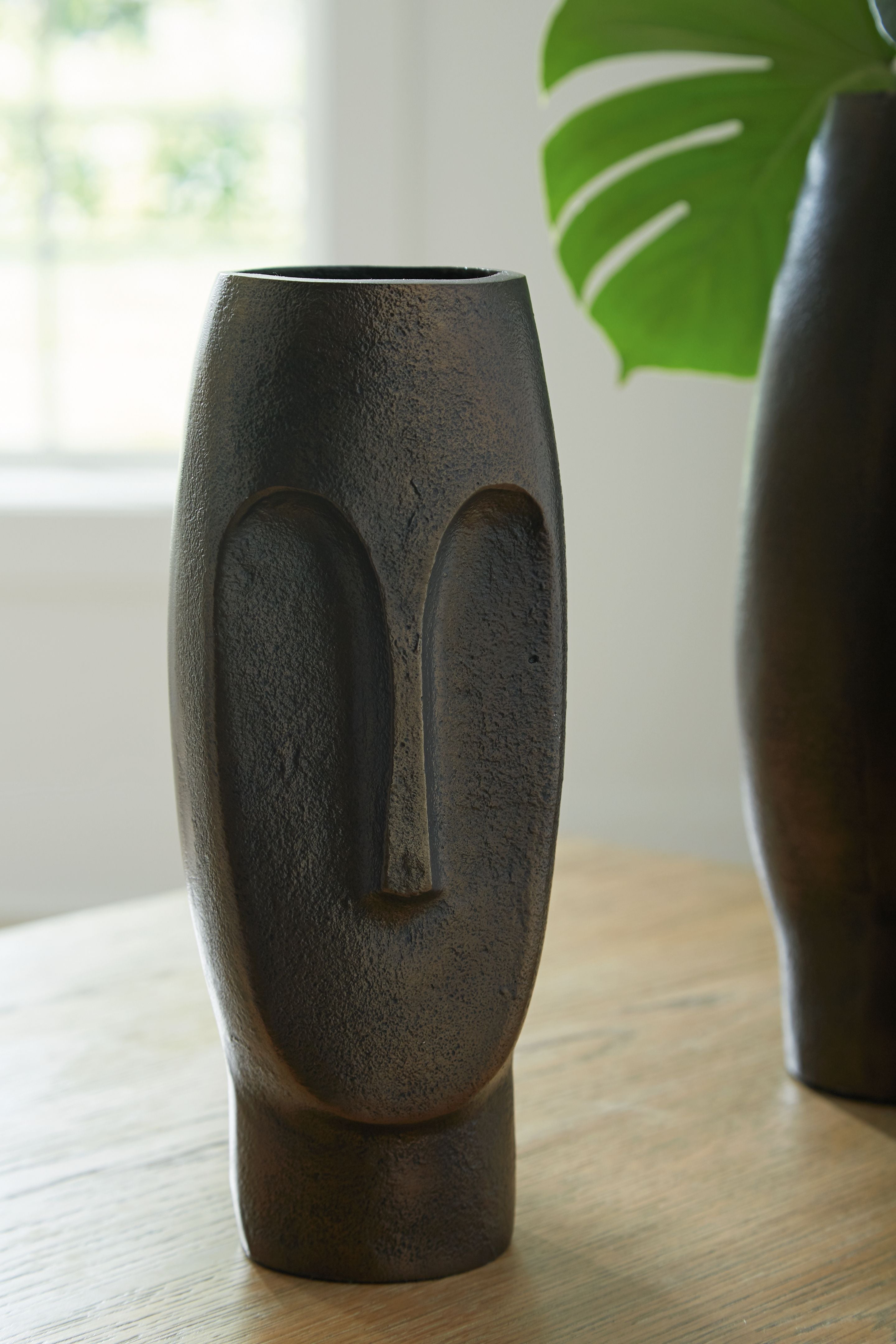 Bronze textured vase with arched cutout, standing on tabletop